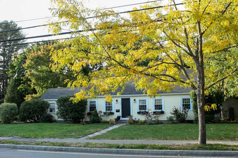 A charming, single-story ranch house with pale yellow siding