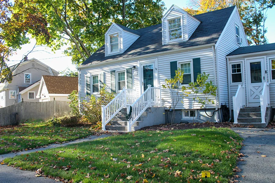 A classic Cape Cod-style home with light grey siding